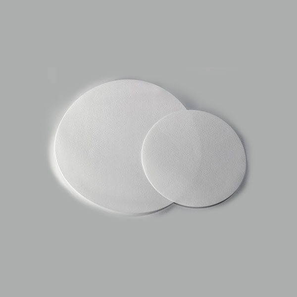 A white circular paper used in biology laboratory for filtering liquids on a white background